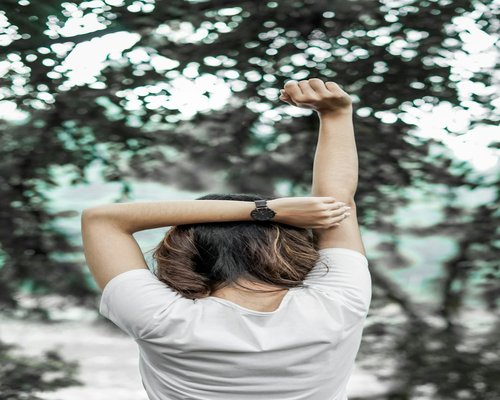 A person stretching their arms gently after a long commute